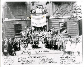 Seventh Zionist convention, St. Patrick's Hall. Men, women and a few children standing or seated in front of building, eight people standing on balcony, Zionist/Israeli flag hanging from balcony. Names of some people written and numbered on original photograph, including Clarence I. De Sola, Rabbi Nathan Gordon, B. M. Weiner, Laz. Philips, M. B. Steine and others.