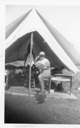 Gordon Allice with a baseball mitt outside a tent