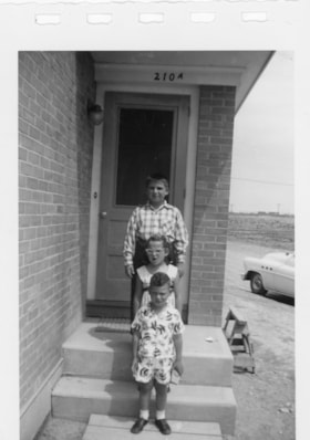 Three unidentified kids on a porch