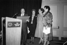 Four people standing around a podium