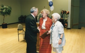 Two unidentified women receive a plaque from President Norman Lesh
