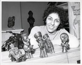 Interior portrait, Esther Dagan with terracotta figurines from a Falasha art exhibit at Galerie Amrad.