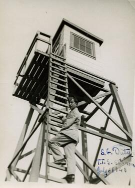 Exterior snapshot of man climping ladder to watch tower, Technical Training School, St. Thomas, Ontario.