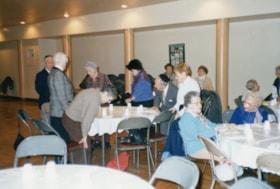 People sitting at tables at a Golden Age Club event
