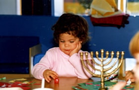 A participant of the Jewish Community Centre Day Care spinning a Chanukah dreidle