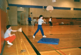 Two unidentified men playing indoor softball