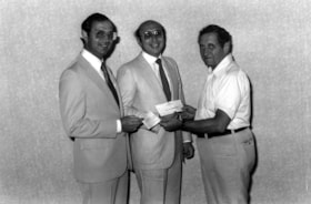 Irving Rivers, Chairman of the Jewish Community Centre - Beth Shalom Synagogue Bingo Committee, presents cheques to Stephen Victor and Dan Kimmel.