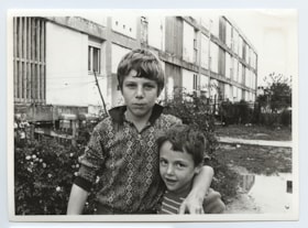 Two young boys standing in front of a building