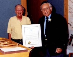 Gdalyah Rosenfeld, right, receiving a framed certificate from Lawrence Freedman, left, at the Ottawa Jewish Historical Society evening in his honour.