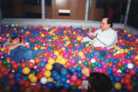 Unidentified man in a ball pit with a child at Cosmic Adventure for a Chanukah event