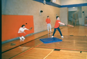 Three unidentified men playing indoor softball