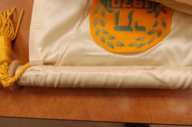 Detail of a white silken banner with yellow cord belonging to the B'nai B'rith Women's Parliament Lodge.