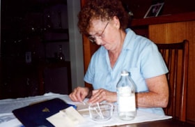 Shirley Berman preforming conservation practices on an archival holding located in the Ottawa Jewish Archives.
