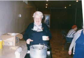 Unidentified woman standing over a pot at a Golden Age Club event