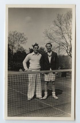 Two unknown men on a tennis court.