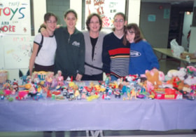 Students running a used toy table fundraiser.