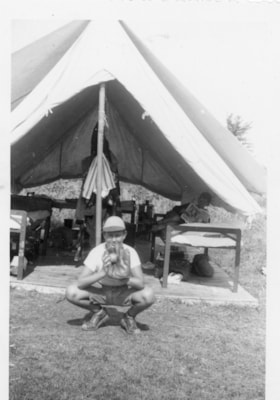 Gordon Allice with a baseball mitt outside a tent
