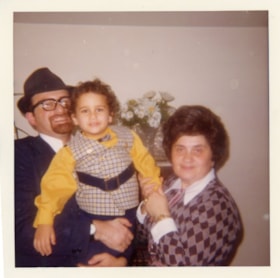 Rabbi Bulka holding his son with an unidentifie woman