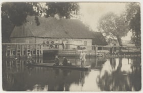 Men on a row boat, boys on the dock