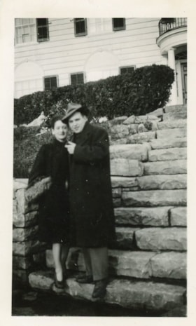 Unidentified couple standing on steps outside a house