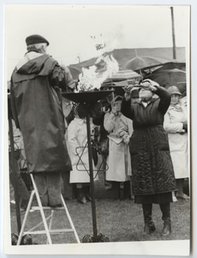 An unidentified woman lighting a flare at Holocaust Memorial