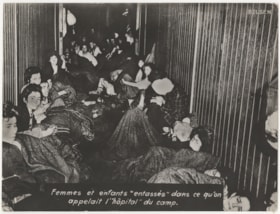 Newly liberated female and hildren prisoners sit in former camp "hospital"