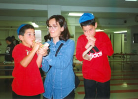 Two boys practice blowing the shofar.