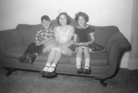 Gordon Allice, Beverly Allice, and an unidentified girl sitting on a couch