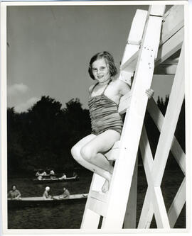 Portrait of young girl on wharf ladder, Camp Wooden Acres, Montreal.